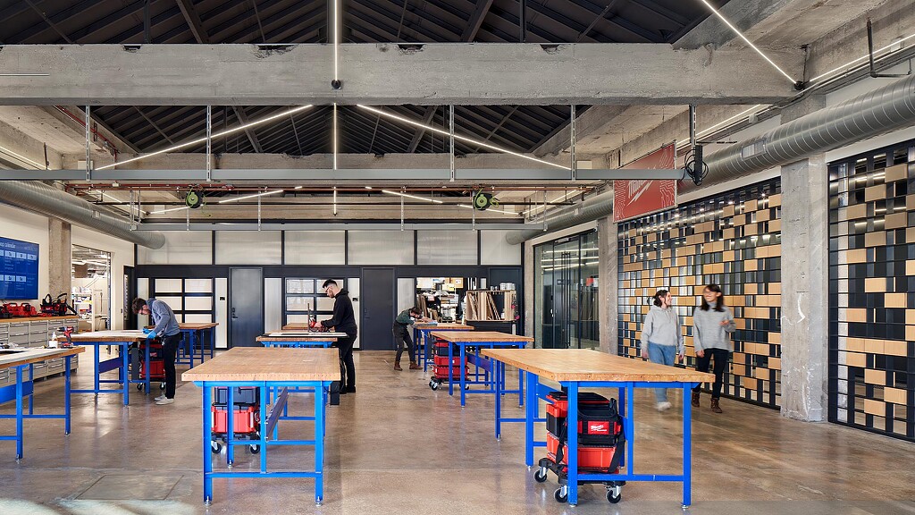 People in a room with tables and blue tables.