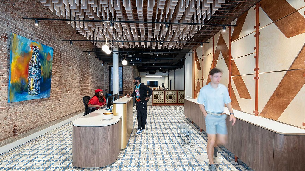 A person standing in a room with a table and chairs.