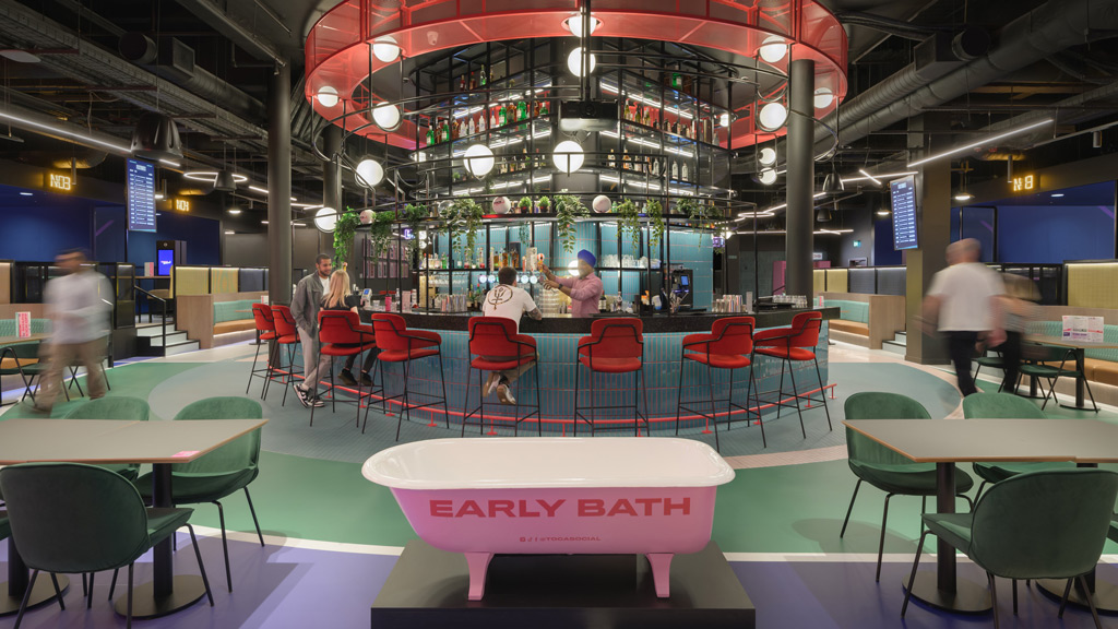 A group of people in a room with tables and chairs.