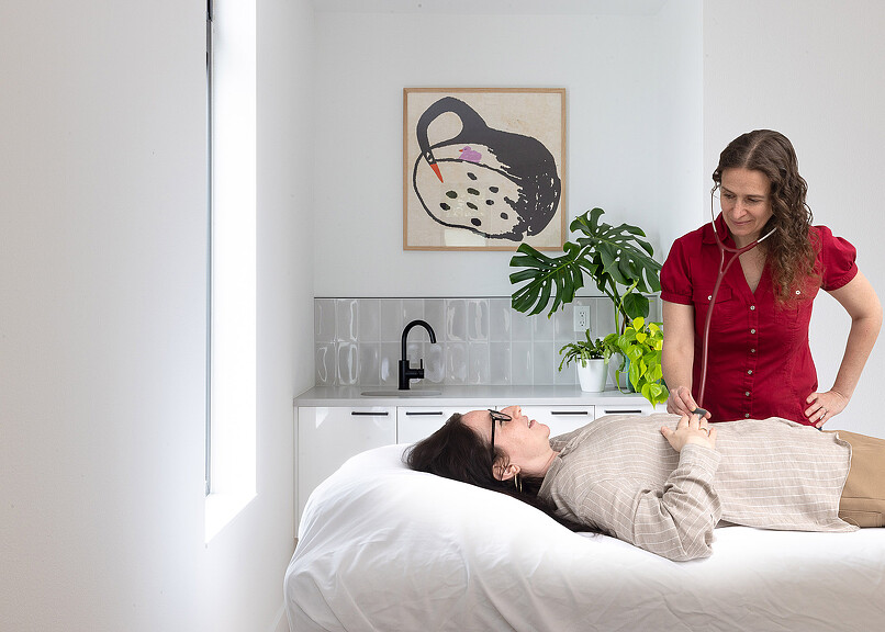 Open Wellness doctor with patient laying on bed