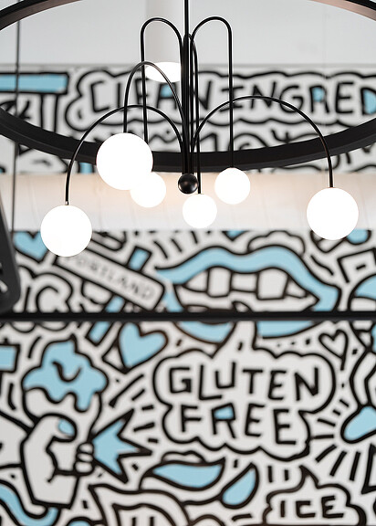 A close-up of Cosmic Bliss ice cream shop light fixture and wall mural