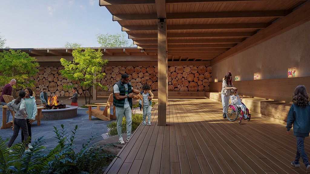 A group of people standing on a deck with a wood structure at UKANDU