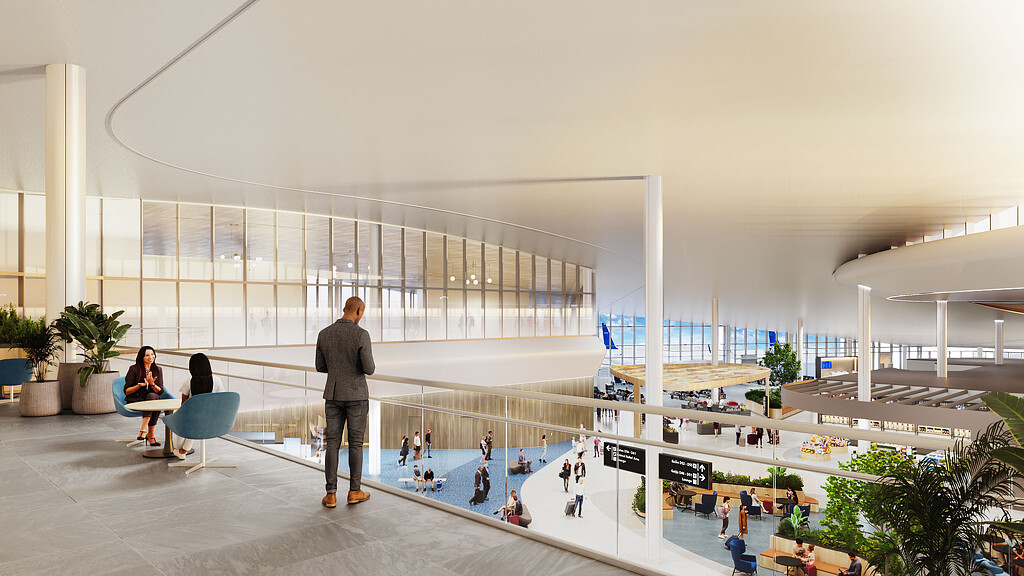 A man and woman standing in a large building with glass walls.
