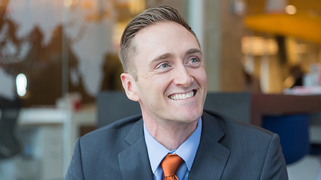 A man in a suit smiling.