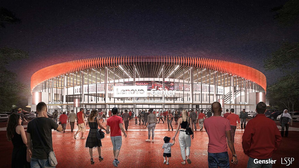 A group of people walking towards a building with lights.