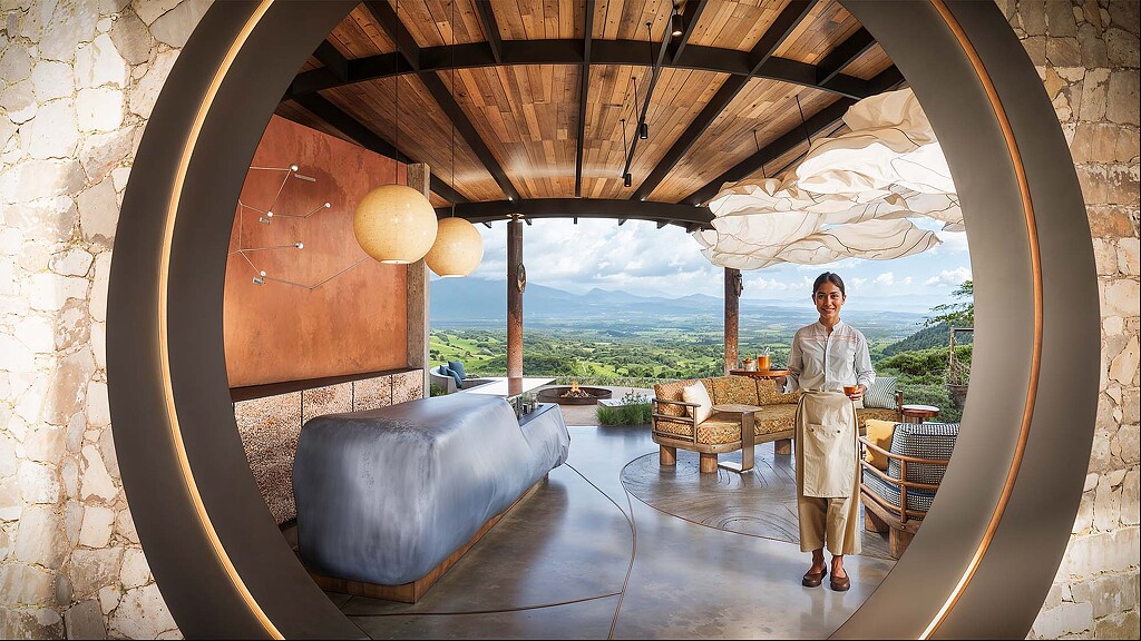 A person standing in a room with a bed and a couch.