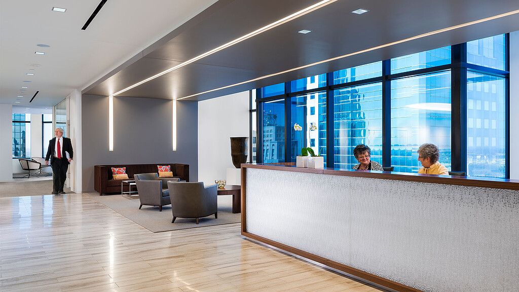 A man and a woman in a room with large windows.