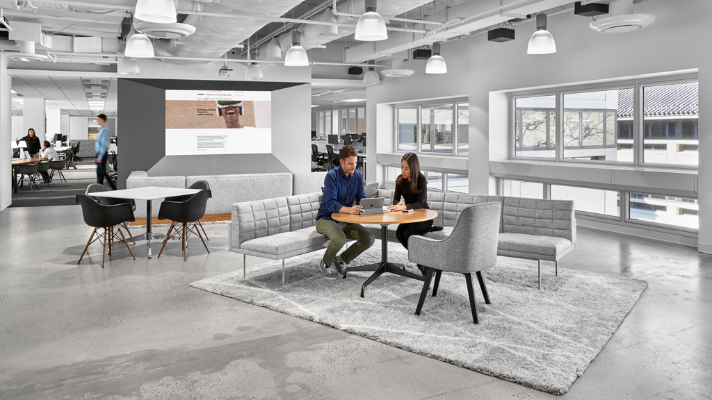 A man and a woman sitting at a table in a large room.