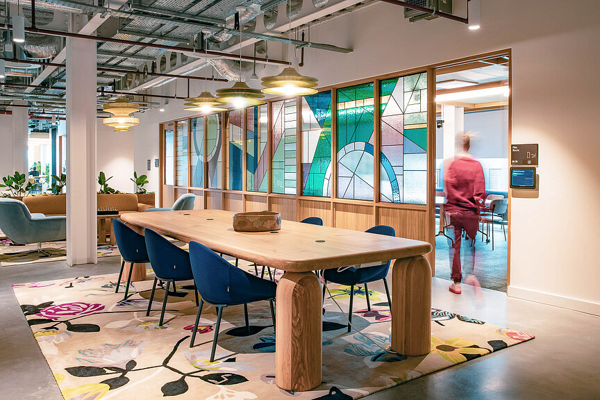 A table with chairs and sliding doors with stained glass window
