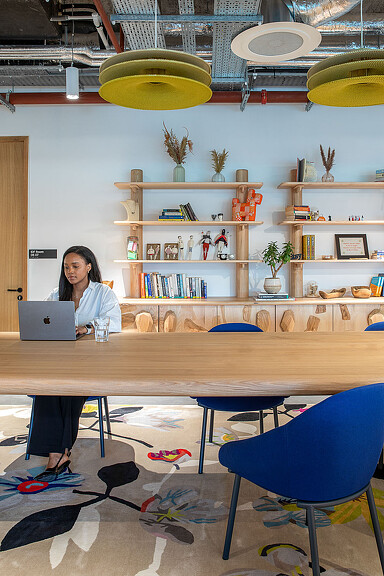A woman sitting at a table with a laptop at Etsy Dublin