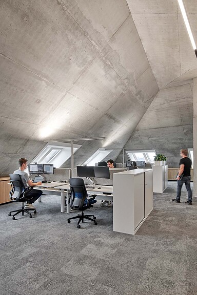 A man and a woman working at a desk with computers.