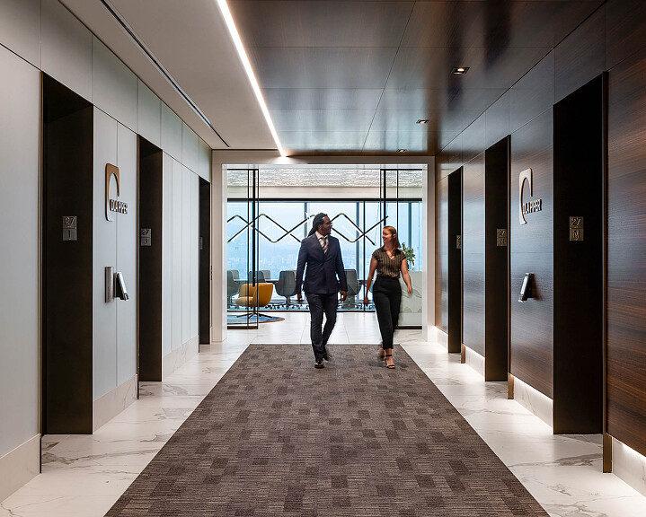 A man and a woman walking in a hallway.