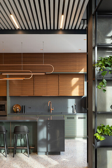 A kitchen with a bar stool and a refrigerator.