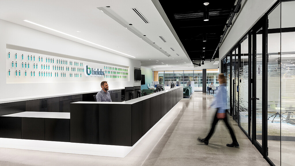 A man and a woman walking in a large building.