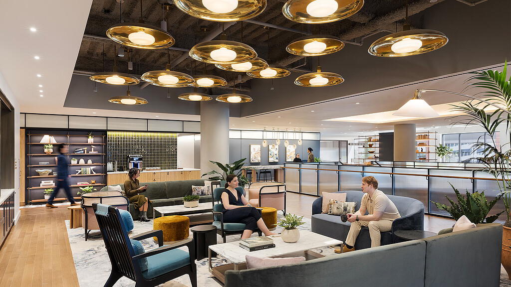 A group of people sitting in a room with a large ceiling.