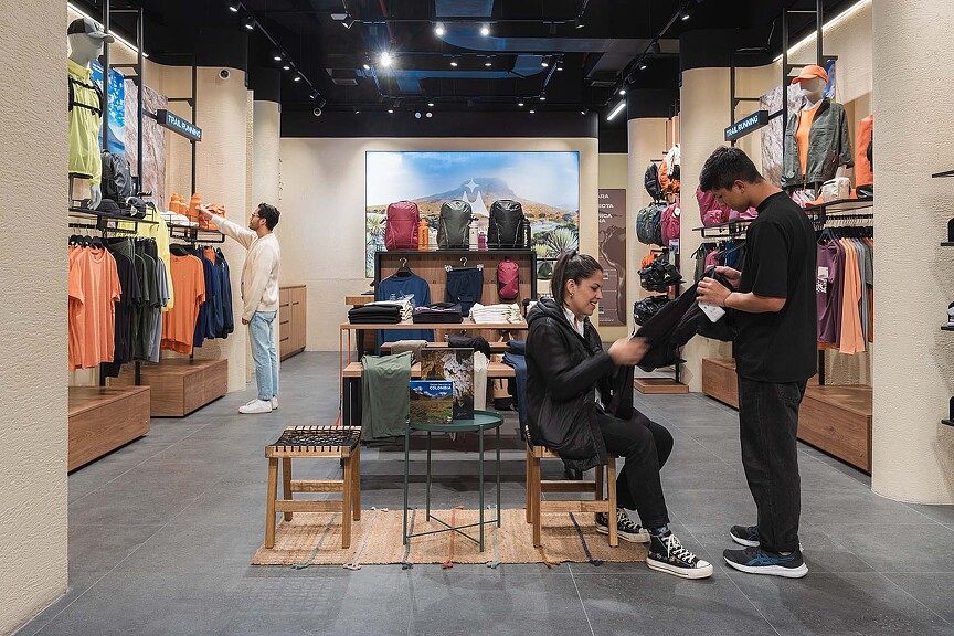 A person sitting in a chair in a clothing store.