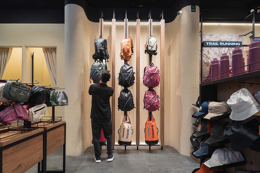 A person looking at a display of hats.