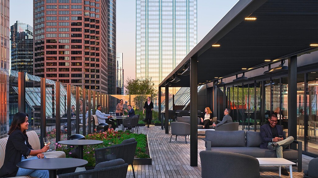 People sitting in a room with tall buildings.