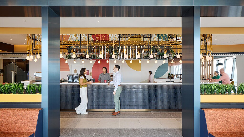 A group of poeple in the kitchen area of the workplace.