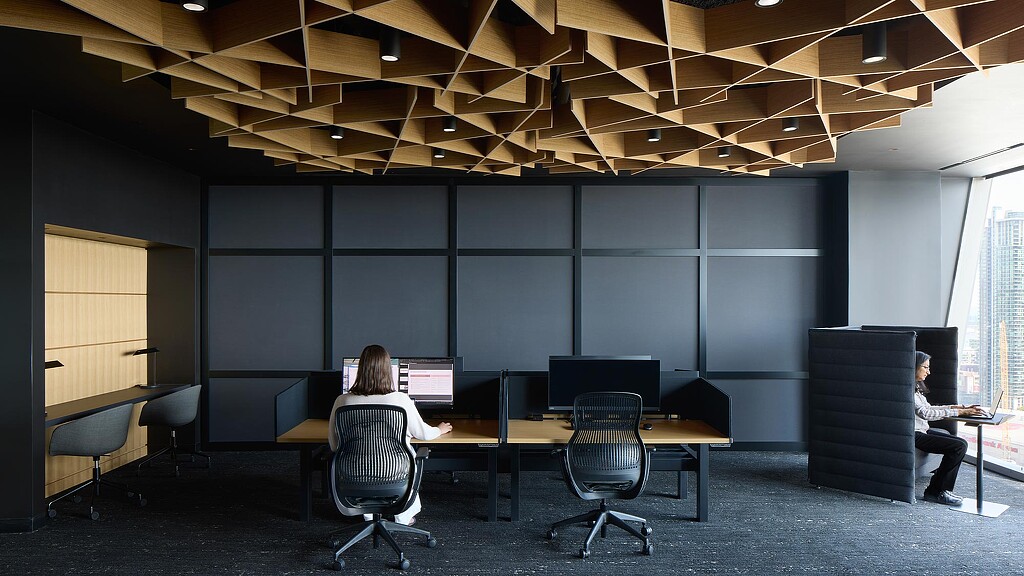 A group of people sitting at a table with computers.