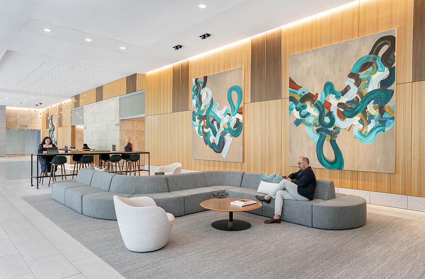 A man and woman sitting on a couch in a room with a map.