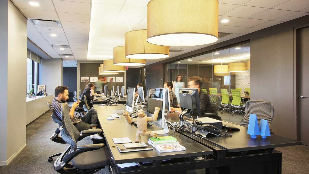 A group of people sitting at a table with computers.