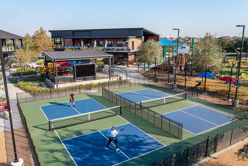 A tennis court with a couple of people on it.