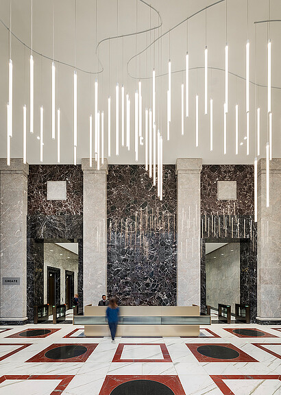 A person standing in a large room with a large wall of art.