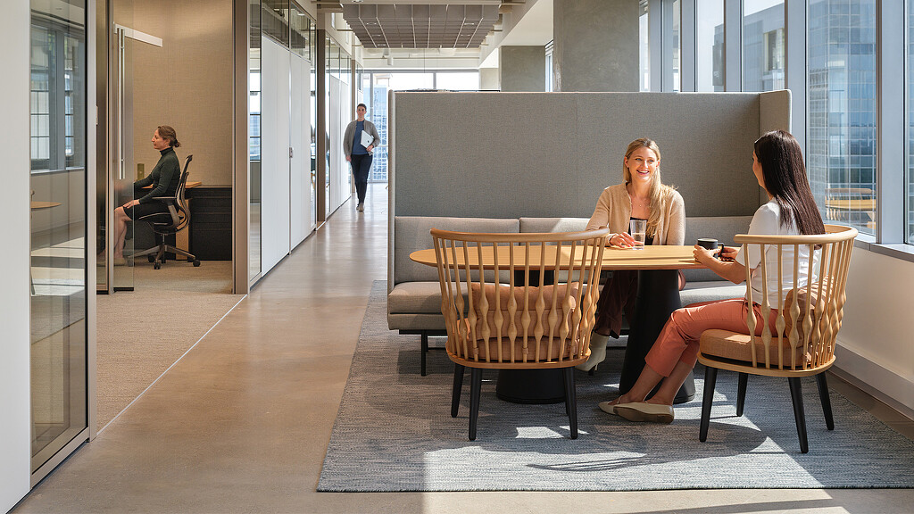 A group of people sitting at a table in a large room.