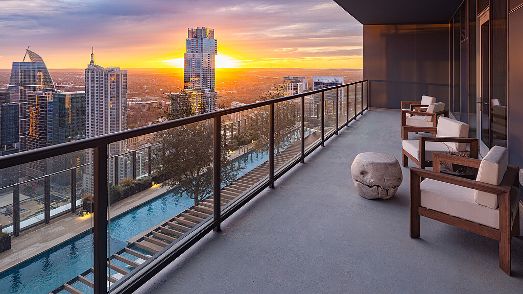 A deck with a view of a city and a large body of water.