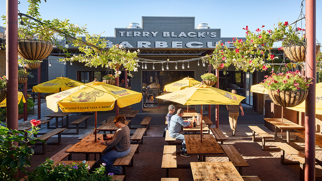 A group of people sitting at a table outside.