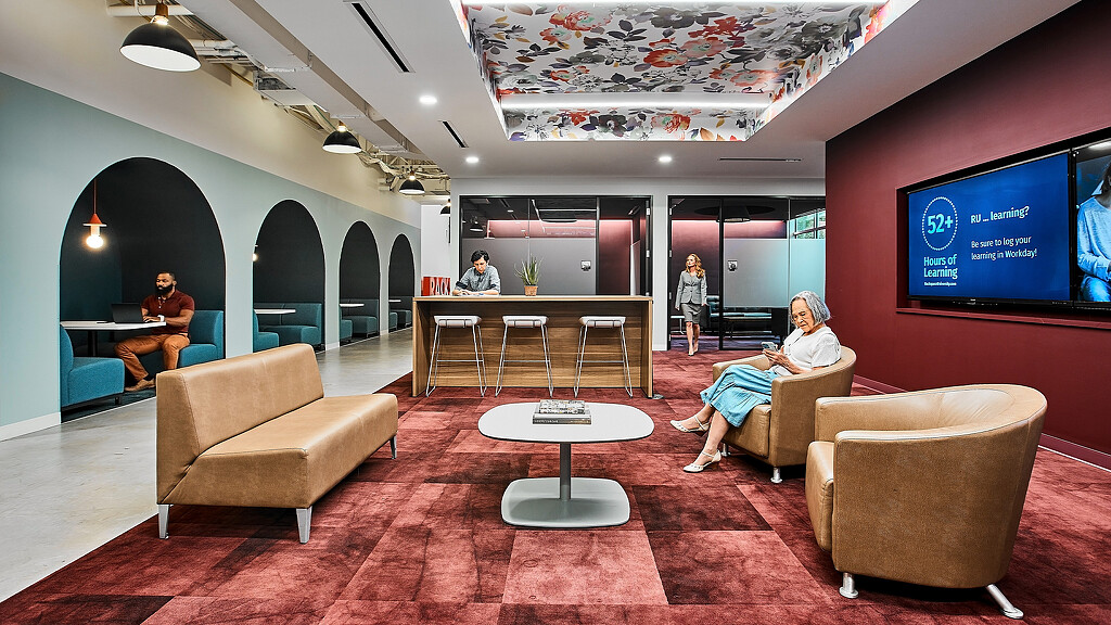 A group of people sitting in chairs in a room with a large screen.