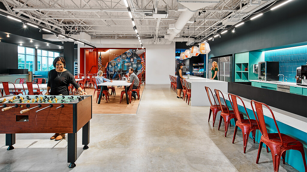 A person standing in a room with tables and chairs.