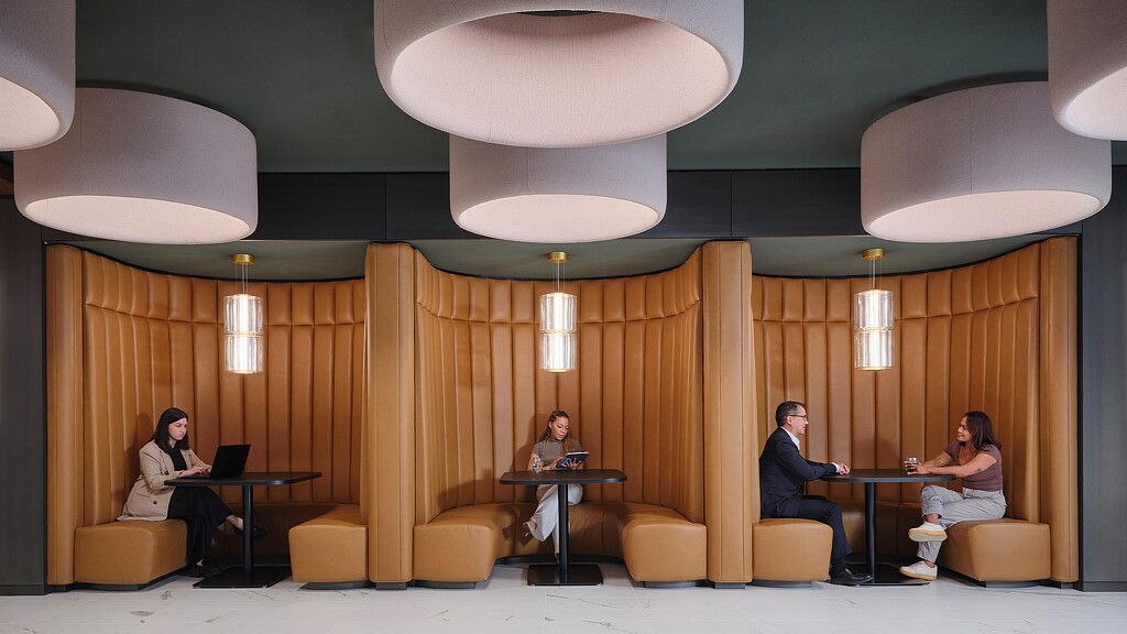 A group of people sitting in a room with a table and chairs.