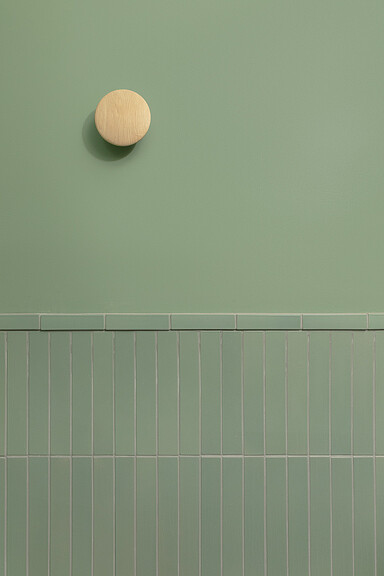 A white wall with a white ball on it.