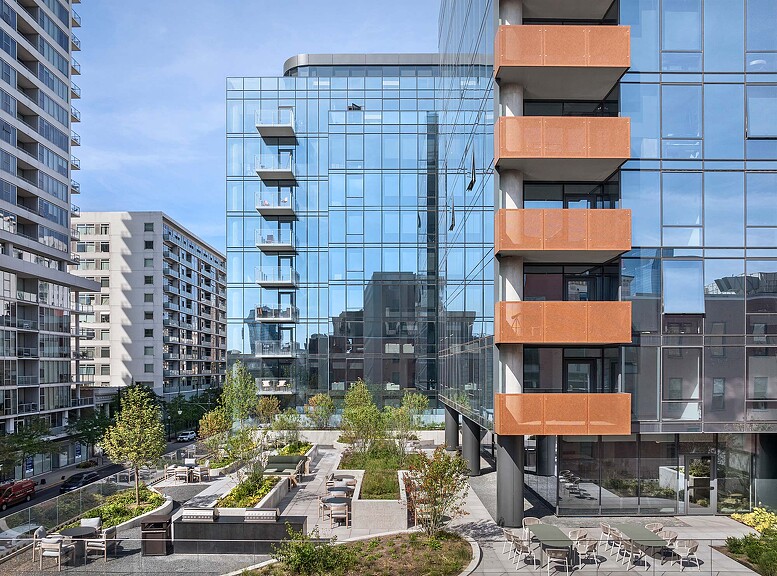 A group of buildings with trees and plants in front of them.
