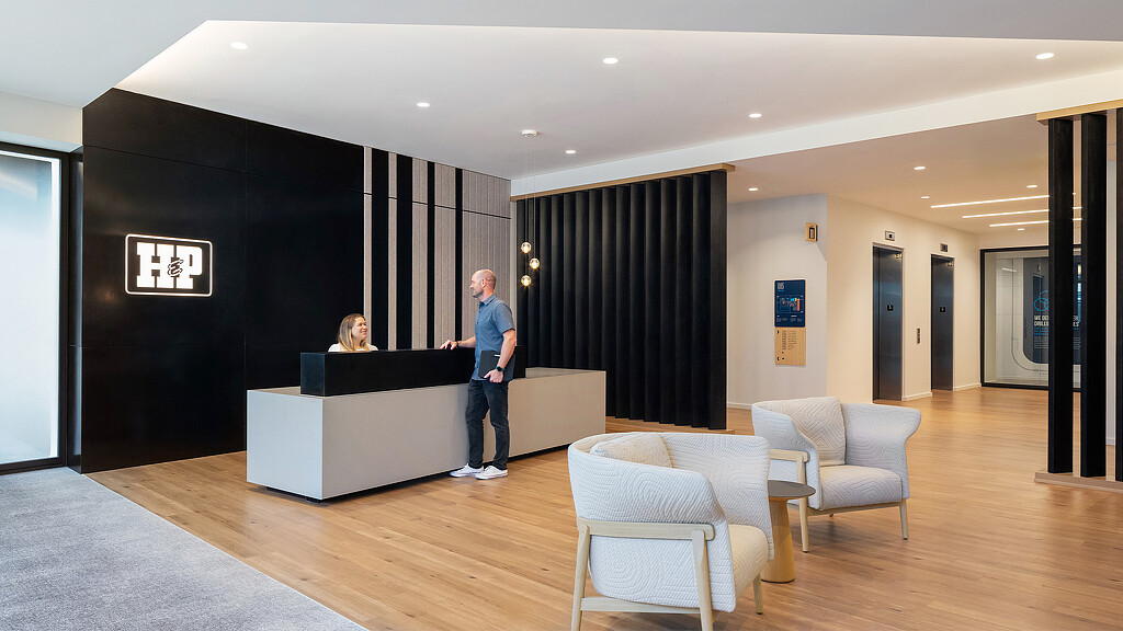 A man and a woman in a room with a large black wall.