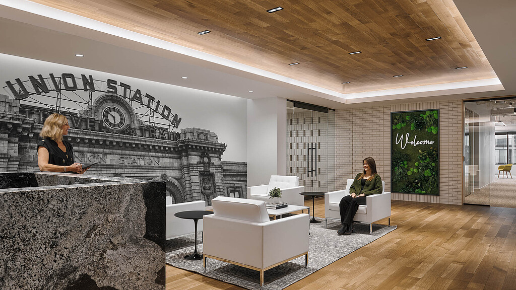 A couple of women sitting in a room with a large stone fireplace.