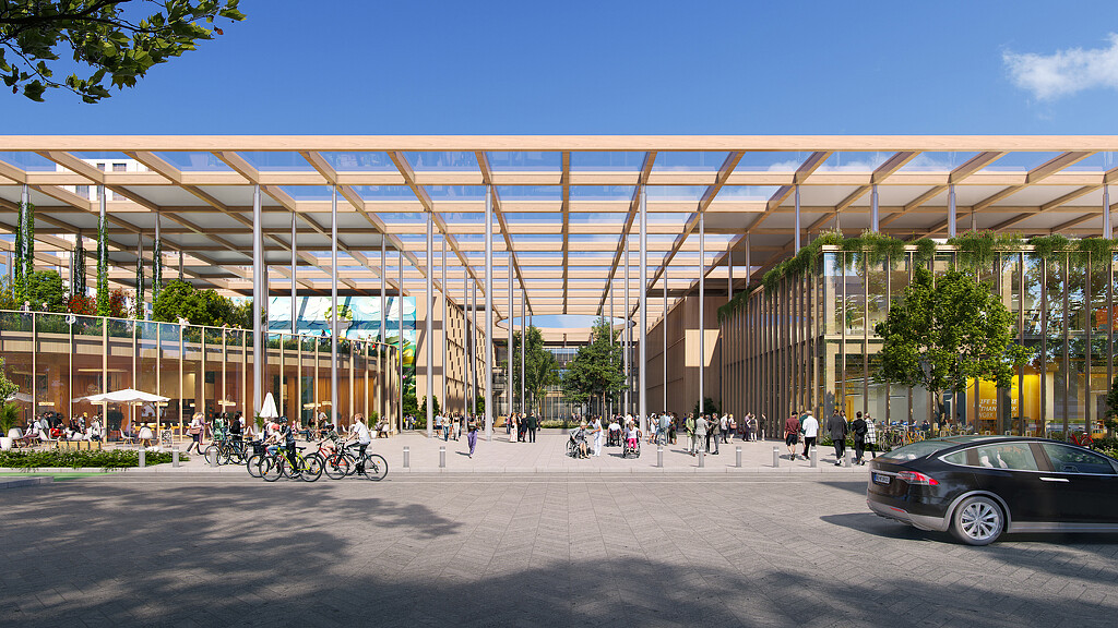 A hospital with a large glass roof and a parking lot with people and bikes.