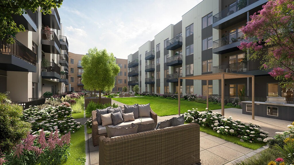 A courtyard with a couch and plants and buildings.