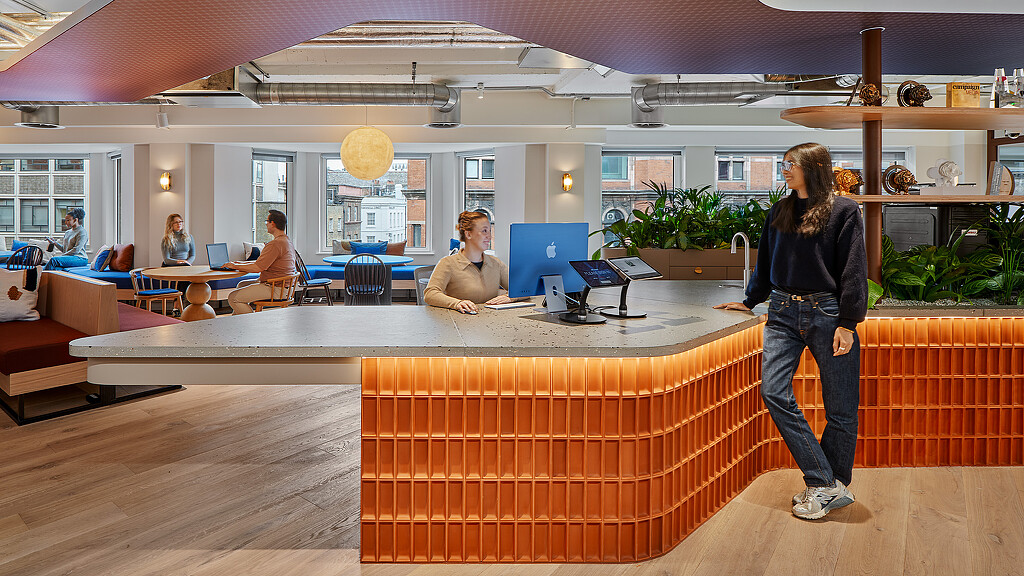 A woman standing in front of a man sitting at a table.