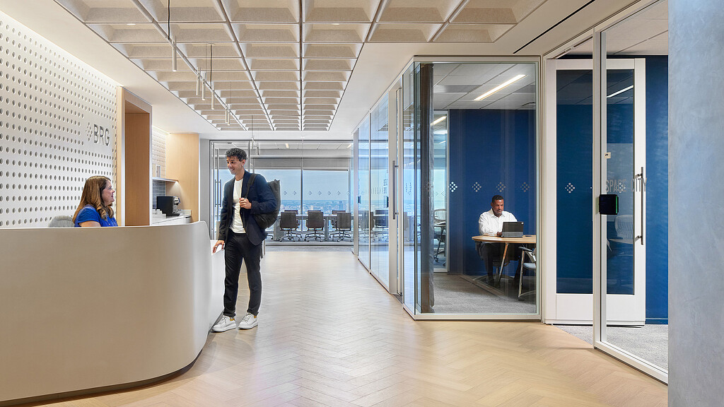 A person standing in a room with glass doors.