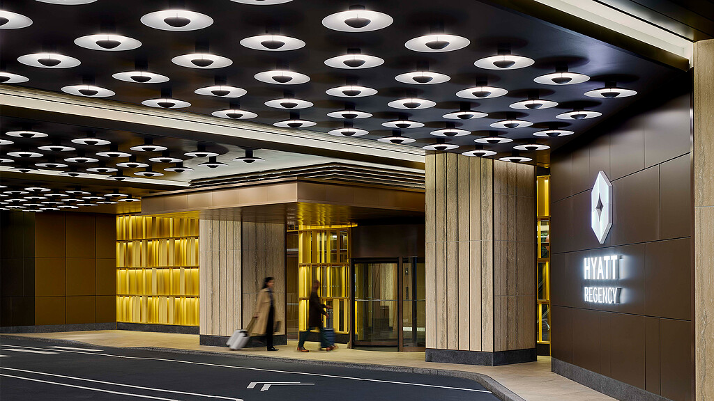 A few people walking in a building.