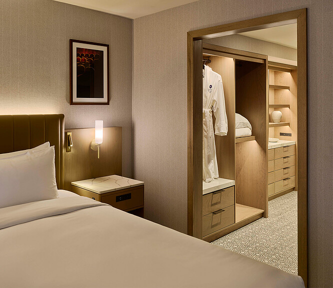 A bedroom with a mirror and a bed.