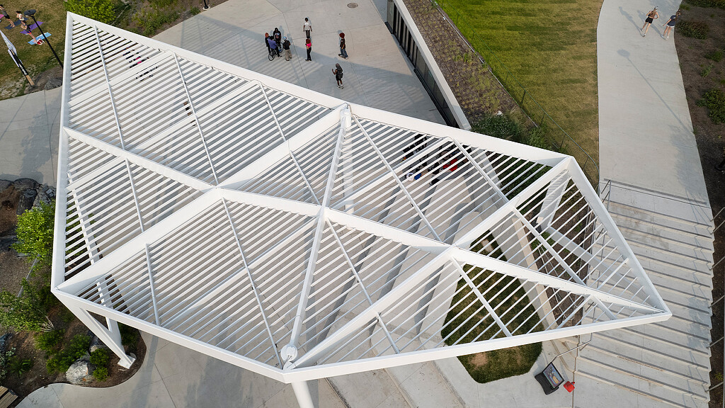A group of people walking on a path next to a white building.