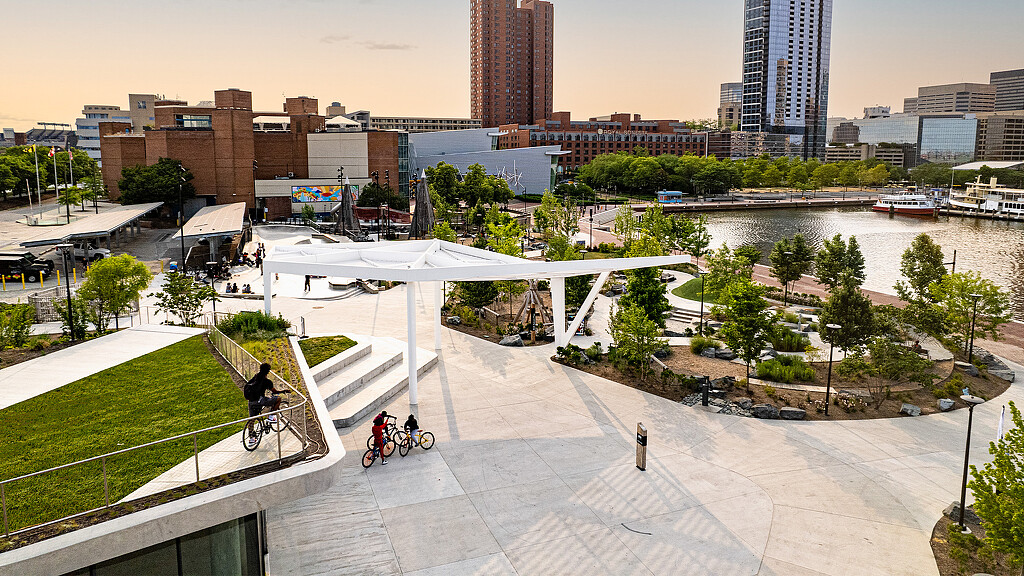 A group of people riding bikes on a bridge over a river.