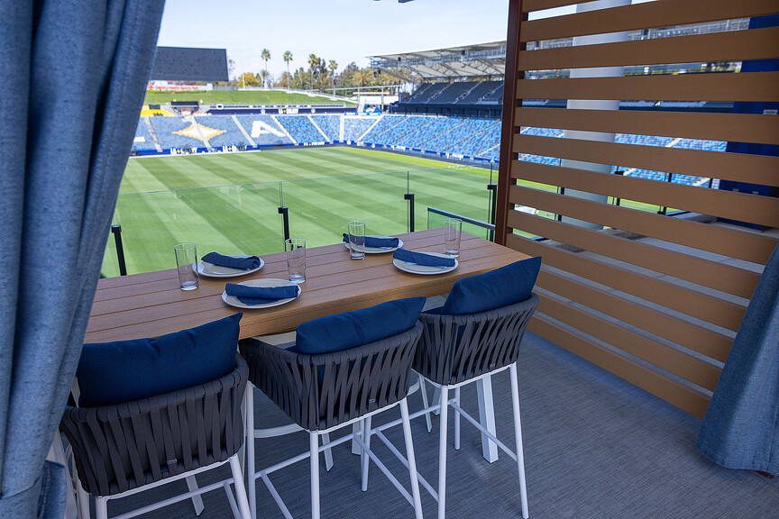 A table with chairs and a field in the background.