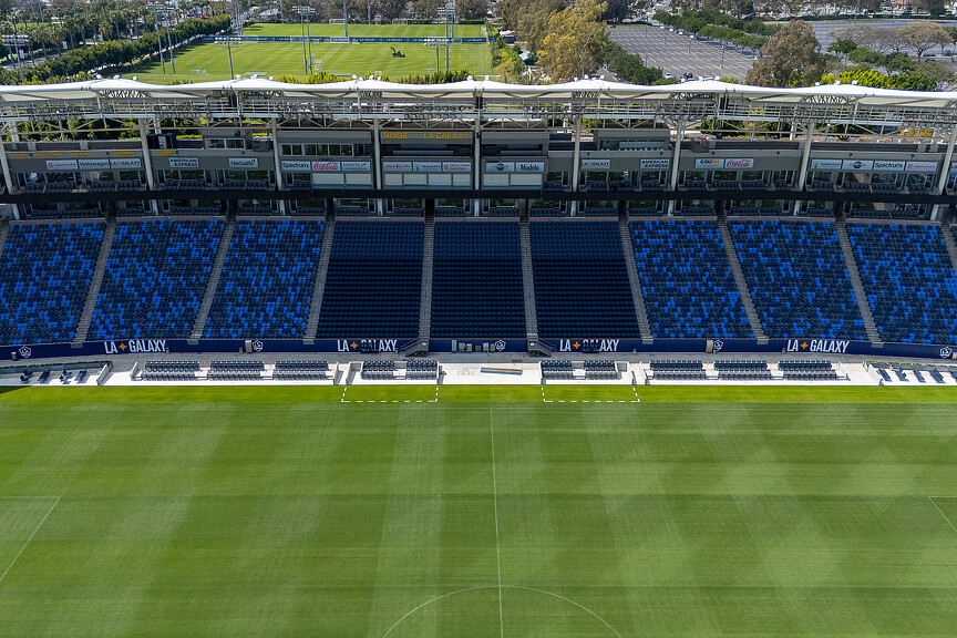 A sports stadium with a green field.