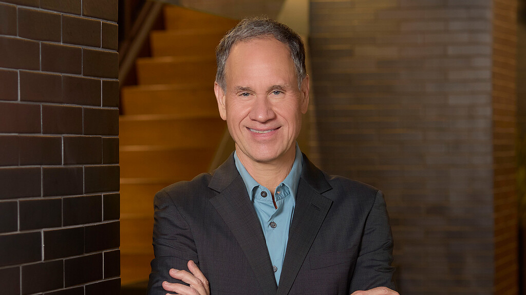 A man in a suit smiling.