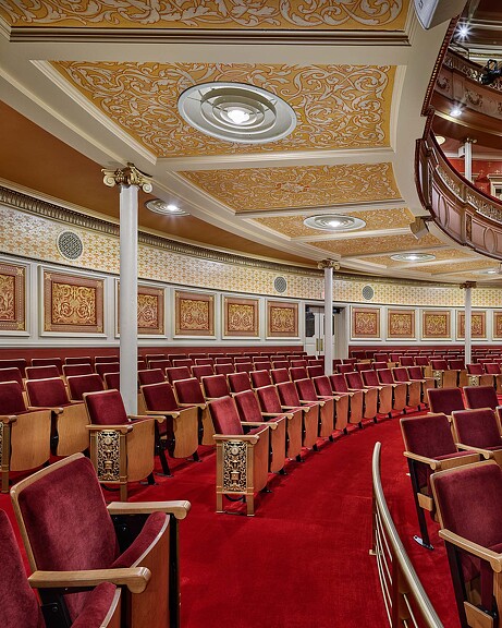 A large room with red chairs.